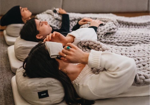 Team resting under blankets during a corporate sound bath