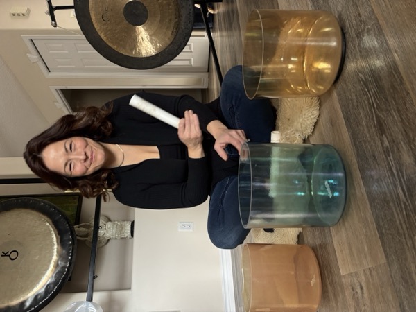 Participant playing crystal singing bowls at a Sound Foundations Playground session