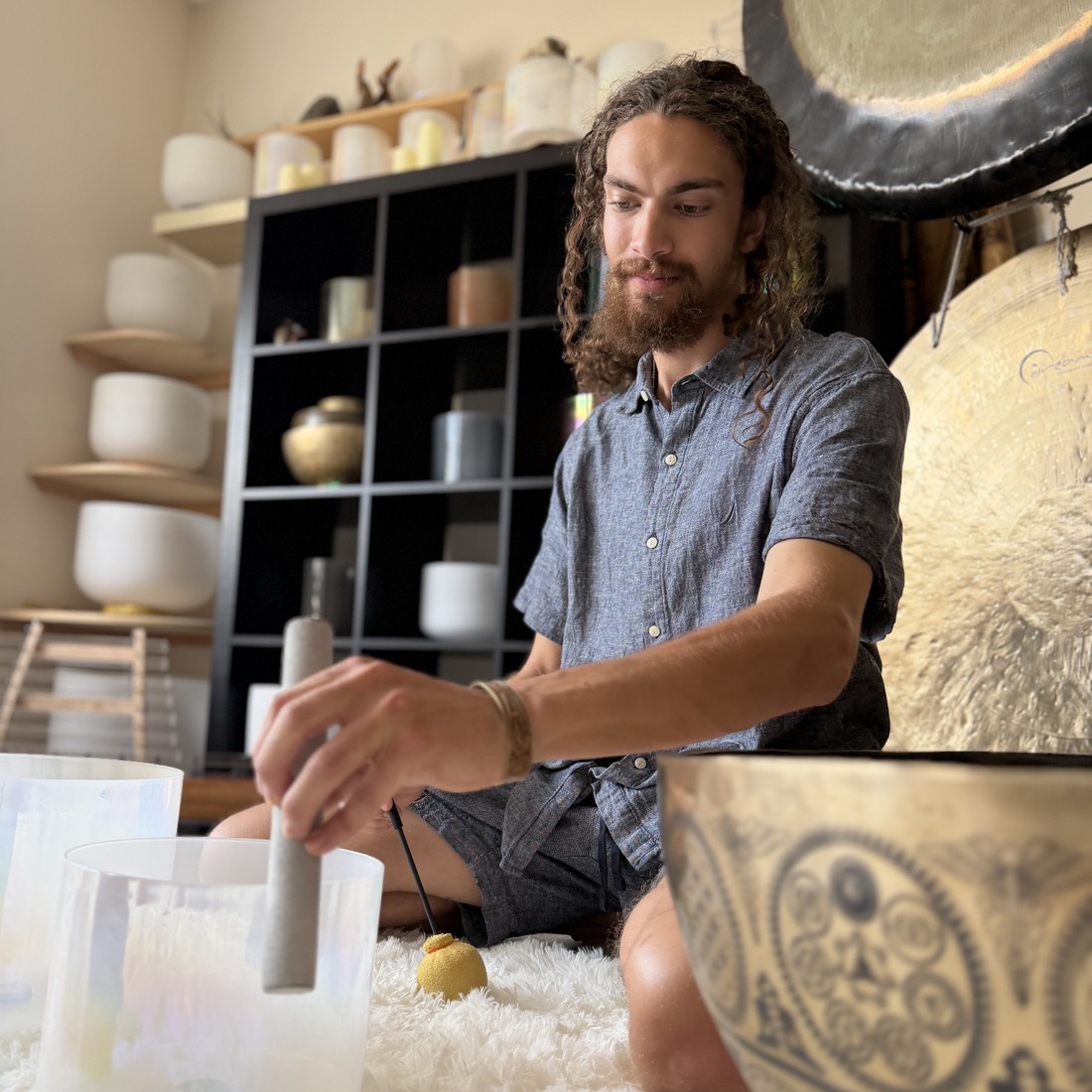 Brock Fritz — sound practitioner with Earth Harmony Sound & Wellness, Edmonton, playing crystal singing bowls